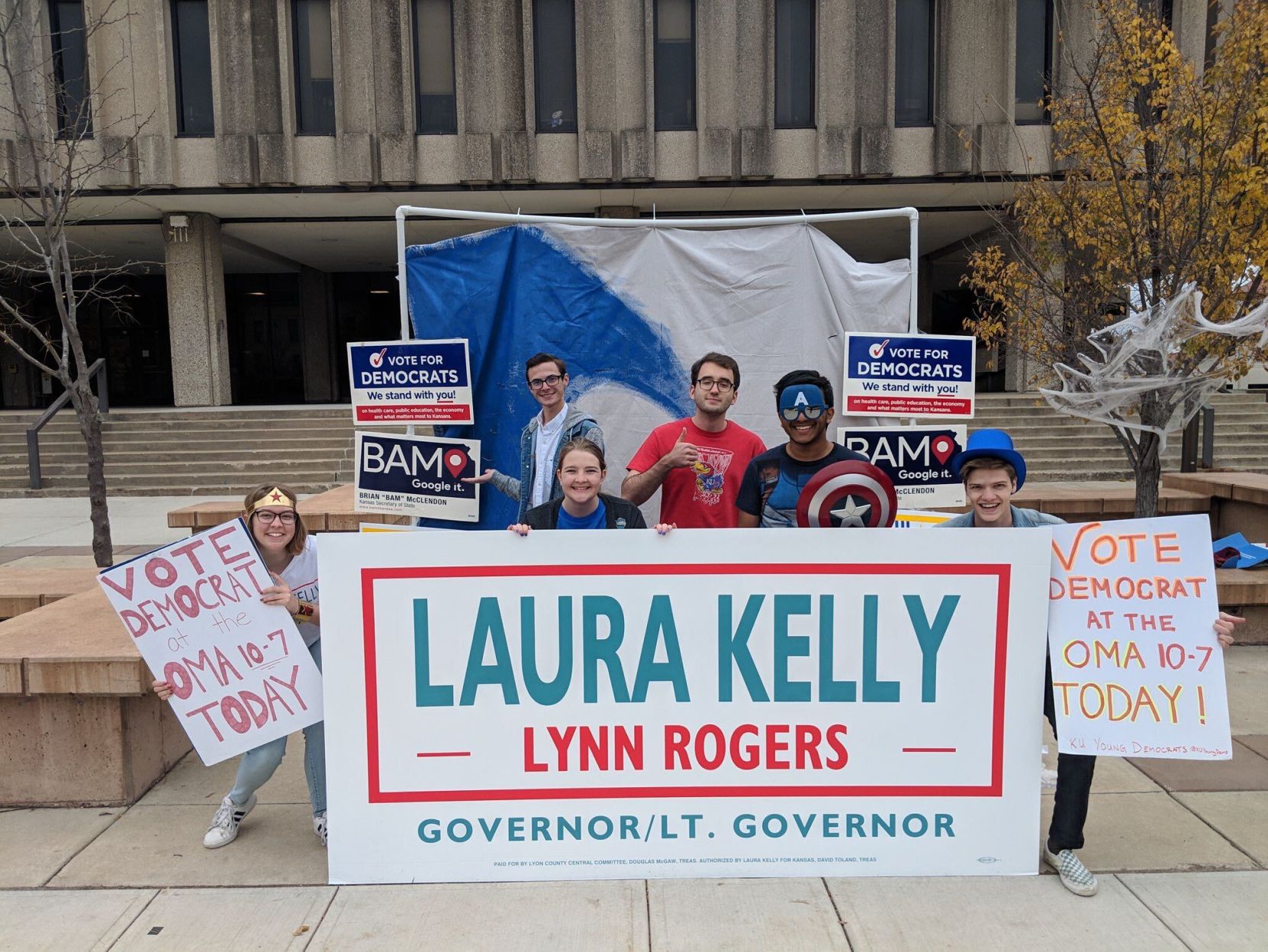 A group of students table for Laura Kelly with posters in front of Wescoe Hall